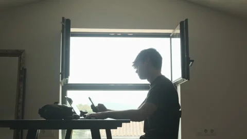 Frustrated man scrolling instagram while editing a video. Silhouette Stock Footage 243424587