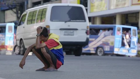 A frustrated man sitting in the middle of the road Stock Footage 130520117