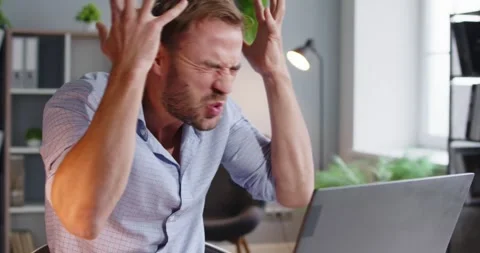 Frustrated man throws hands at laptop during remote work error and online stress Stock Footage 325026106