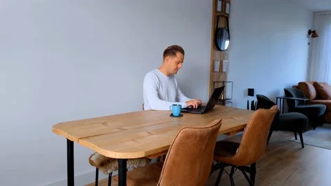 Frustrated man is working from home on a table with his laptop Stock Footage 211903474