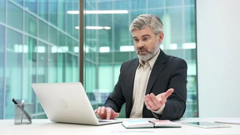 Frustrated mature businessman having difficulty making transaction using laptop  Stock Footage 312731745