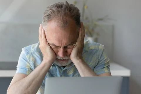 Frustrated middle aged man having problems using computer. Stock Photos