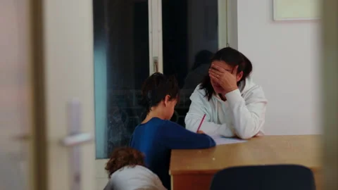 Frustrated mother corrects her son during evening homework at the home tabl.. Video stock 343656421