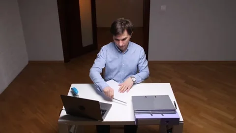 Frustrated office worker crumples paper at desk after work failure Stock Footage 306549247