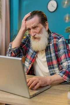 Frustrated senior man having software problems with laptop, angry man get Stock Photos