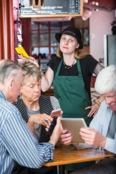Frustrated Server Waiting on Customers with Electronics Stock Photos