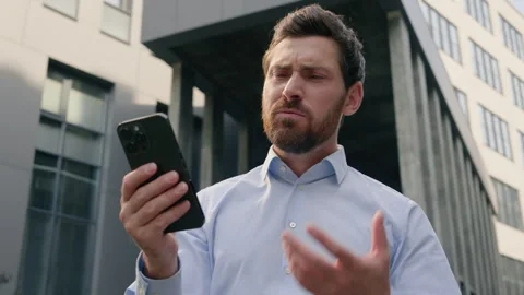 Frustrated stressed disappointed Caucasian male holding mobile phone error app Stock Footage 290778444