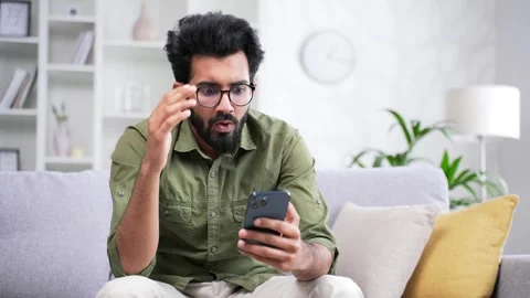 Frustrated stressed handsome bearded man reads bad news on a smartphone while  Stock Footage 252200818