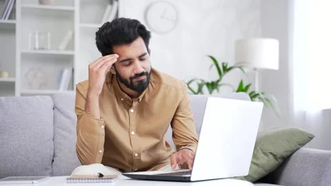 Frustrated stressed handsome bearded man reads bad news on laptop while sitting  Stock Footage 252207030