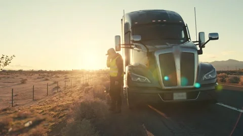 Frustrated truck driver calling for help on a desert highway at sunset Stock-Footage 346972480
