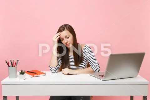 Frustrated woman in desperation leaning on hand looking down sit, work at white Stock Photos