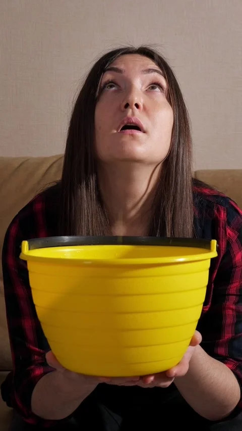 Frustrated woman looking up at a leaky ceiling catching dripping water in a Stock Footage 342943500