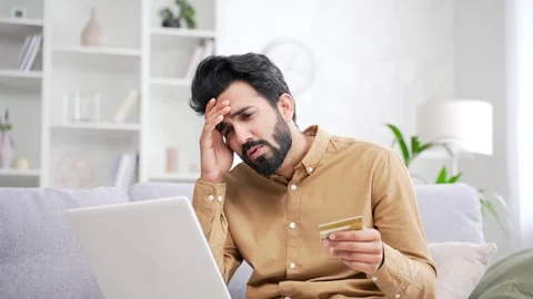 Frustrated young handsome bearded man discovered fraud while entering credit  Stock Footage 252200532
