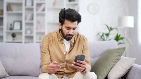 Frustrated young handsome bearded man discovered fraud while entering credit  Stock Footage 252213309