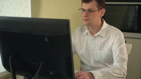 Frustrated young handsome man looking exhausted while sitting at his working Stock Footage 86079563