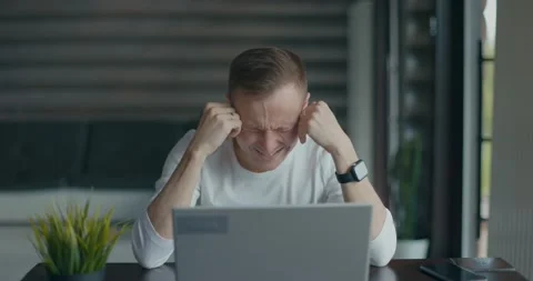 Frustrated young man sitting in front of his laptop after reading bad news, says Stock Footage 197816101