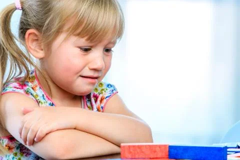 Frustrated youngster at table with game. Stock Photos