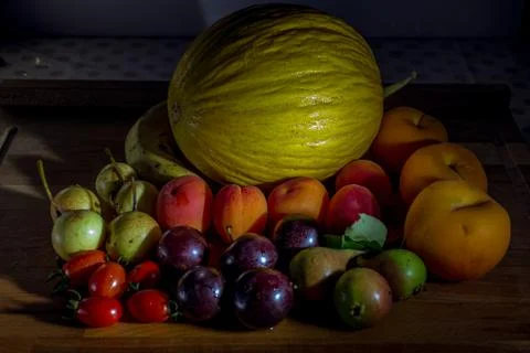  frutas frescas de estación sobre mesa de madera con melon, peras, tomates, dura Stock Photos
