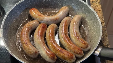 Fry 6 bratwursts in a pan Stock Footage 257942235