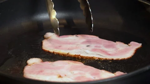 Fry the bacon in a pan. A slice of pork bacon is prepared in its own fat. Stock Footage 239766984