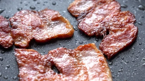 Fry the Bacon Pieces in a Pan. Crispy Pieces of Delicious Bacon are Fried in a Stock Footage 170005879