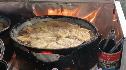 Fry the bananas in a large frying pan and the red fire is on Stock Footage 274067213