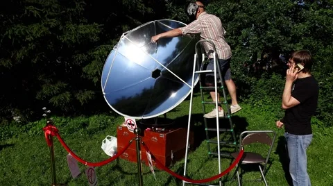 Fry bread on sun rays focused by paraboloid reflector, scientific exhibition Video stock 65486234