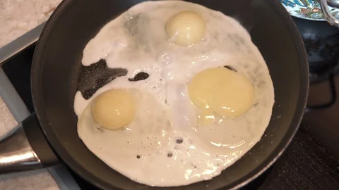 Fry chicken eggs on a pan, prepare omelette Stock Footage 85775498