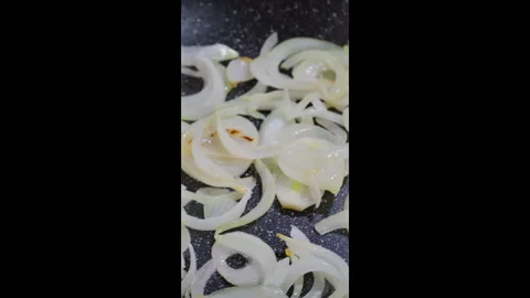Fry chopped onion in a pan. The cook shakes the pan to stir the onions. Video stock 302636724