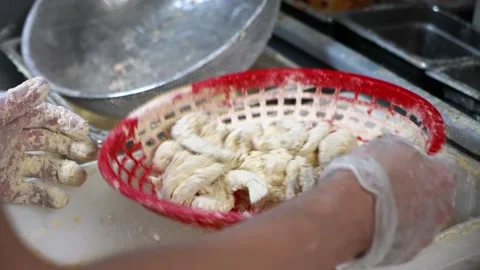Fry cook uses red basket as strainer to bread raw shrimp, slow motion 4K 스톡 동영상 218876184