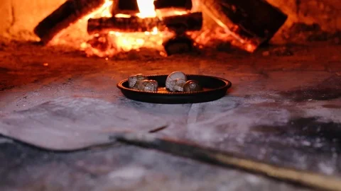 Fry cooking snail escargots in a heating oven with open fire and burning woods Stock Footage 129458598
