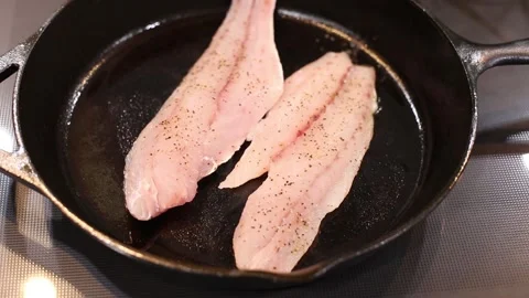 Fry Coooking Red Fish White Meat on Cast Iron skillet video Stock Footage 137759463