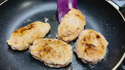 Fry the cutlets in a frying pan and stir with a purple spatula Stock Footage 255729806