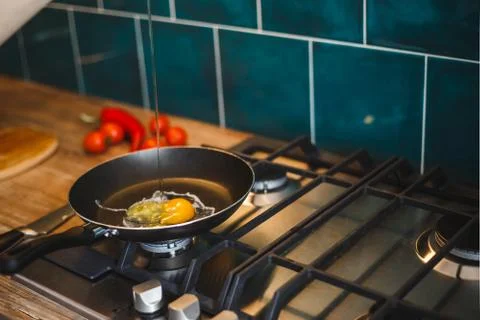 To fry an egg in a frying pan, in the kitchen Stock Photos