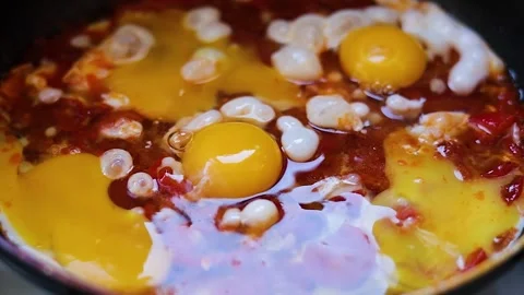 Fry eggs and vegetables in a frying pan close-up. Shakshuka cooking. Healthy fre Stock Footage 247446961