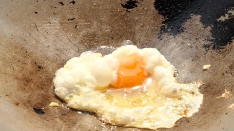 Fry the eggs in the pan until burned. Stock Footage 148659631