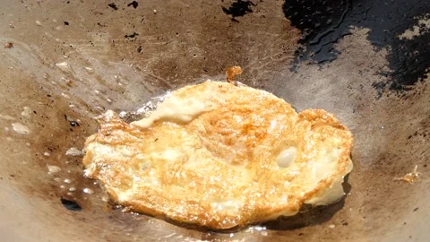 Fry the eggs in the pan until burned. Stock Footage 148659754