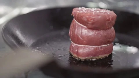 Fry a nice steak of fresh meat in a frying pan using oil. Bubbling oil bubbles Stock Footage 74718940