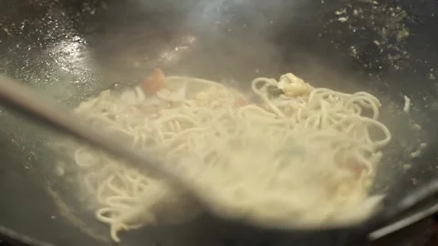 Fry the noodles in a frying pan while stirring 스톡 동영상 265934653