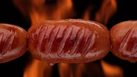 Fry sausages on open fire. Grilled sausages with Flame fire on background Stock-Footage 160553322