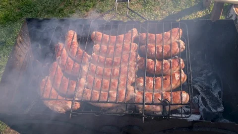 Fry sausages over an open fire Stock Footage 130108846