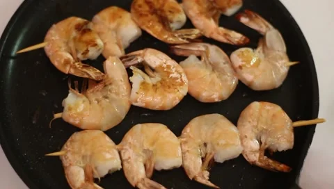 Fry shrimp, string on wooden sticks, fry in a pan. White background, close-up. Stock Footage 170478139
