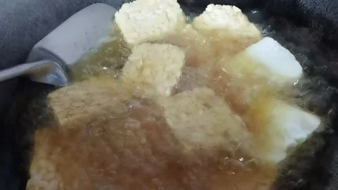 Fry tempeh in a pan using sanco oil Stock Footage 226732523