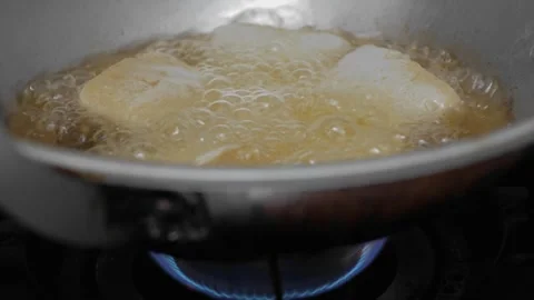 Fry the tofu on a griddle over a blue flame so that the cooking oil becomes.. Stock Footage 241375105