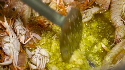 Frying and mixing of different seafood with garlik in big pan. Close up Stock Footage 74523492