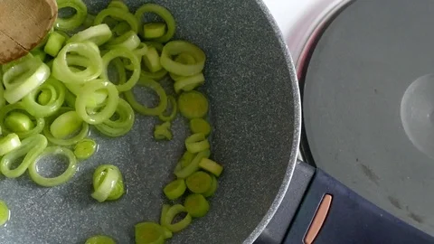 Frying and stirring leek, dolly shot Stock Footage 73041308