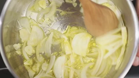Frying and stirring of sliced onion and garlic in a frying pan. Stock Footage 153485219