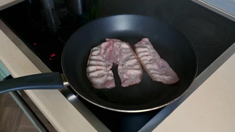 Frying bacon for breakfast. Fry the Bacon Pieces in a Pan. Crispy Pieces of D Stock Footage 152250899