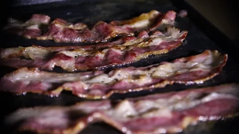 Frying bacon on a grill Stock Footage 144034776