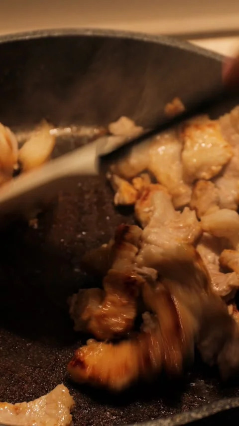 Frying bacon in a pan and stirring it with a silicone spatula during the cooking Stock Footage 314267161